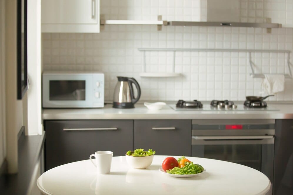 modern-kitchen-white-table-mug-green-salad-2025-interior-design-trends-by-mbm-interior-design